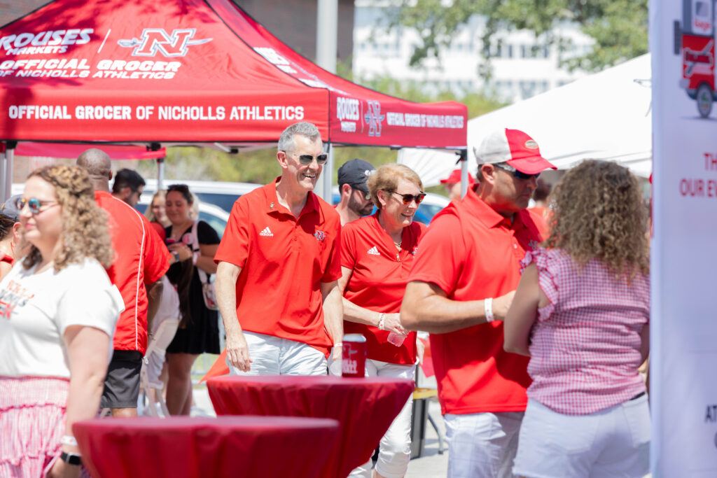 Two people talking and enjoying a nicholls alumni tailgates